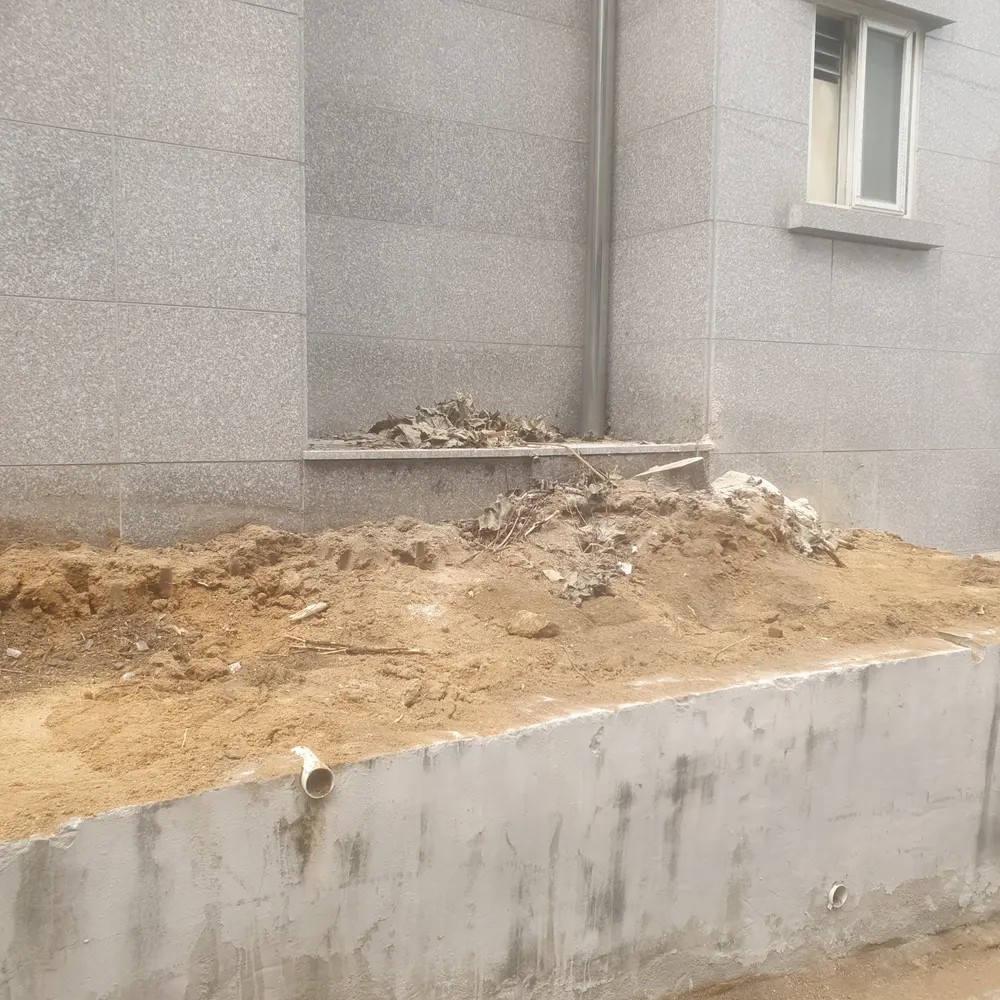 담장철거 — 담장 주변 흙과 잔재를 정리하는 모습